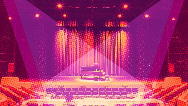 空无一人的舞台上有一架大钢琴，上面覆盖着紫色和橙色.